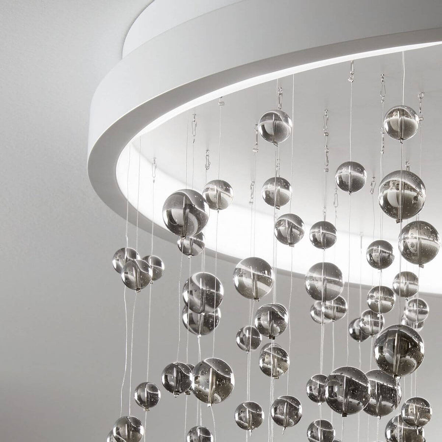 Détail rapproché des sphères de verre transparent et du bandeau lumineux blanc