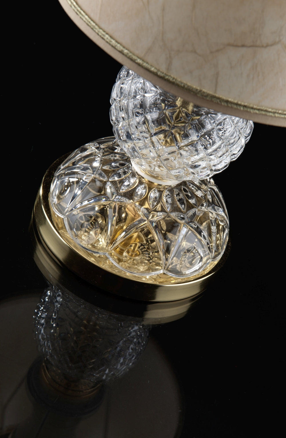 Détail rapproché du socle en cristal taillé et de sa base dorée brillante