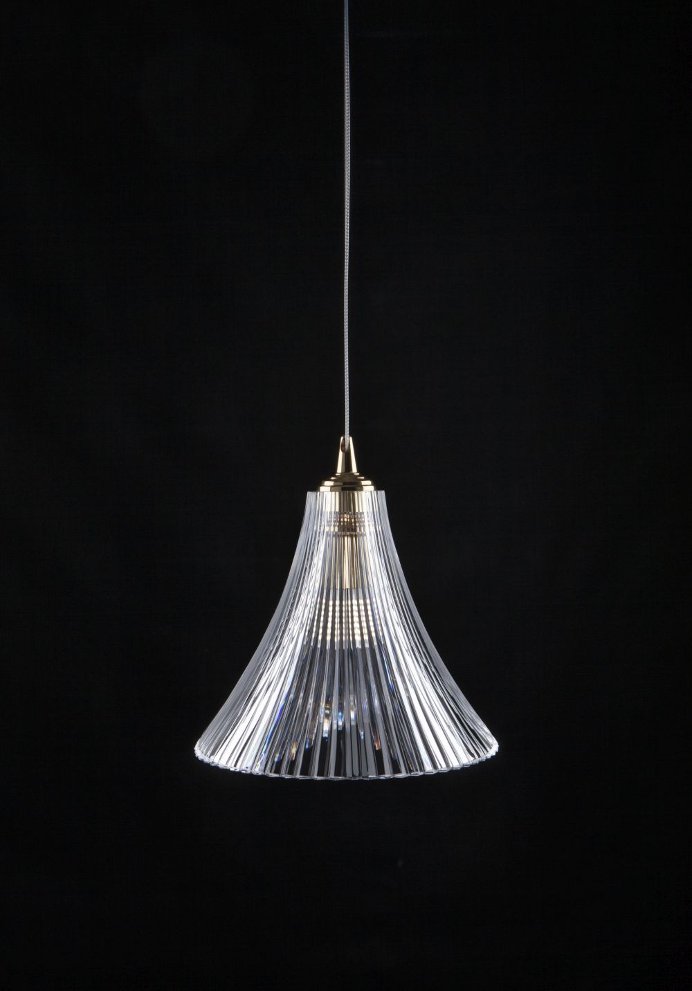 Vue de face du luminaire, câble tressé et douille dorée sur fond noir