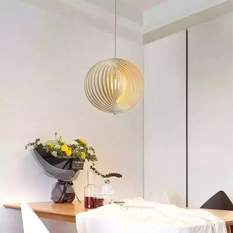 Suspension boule en bois clair au-dessus d'une table à manger avec bouquet de fleurs