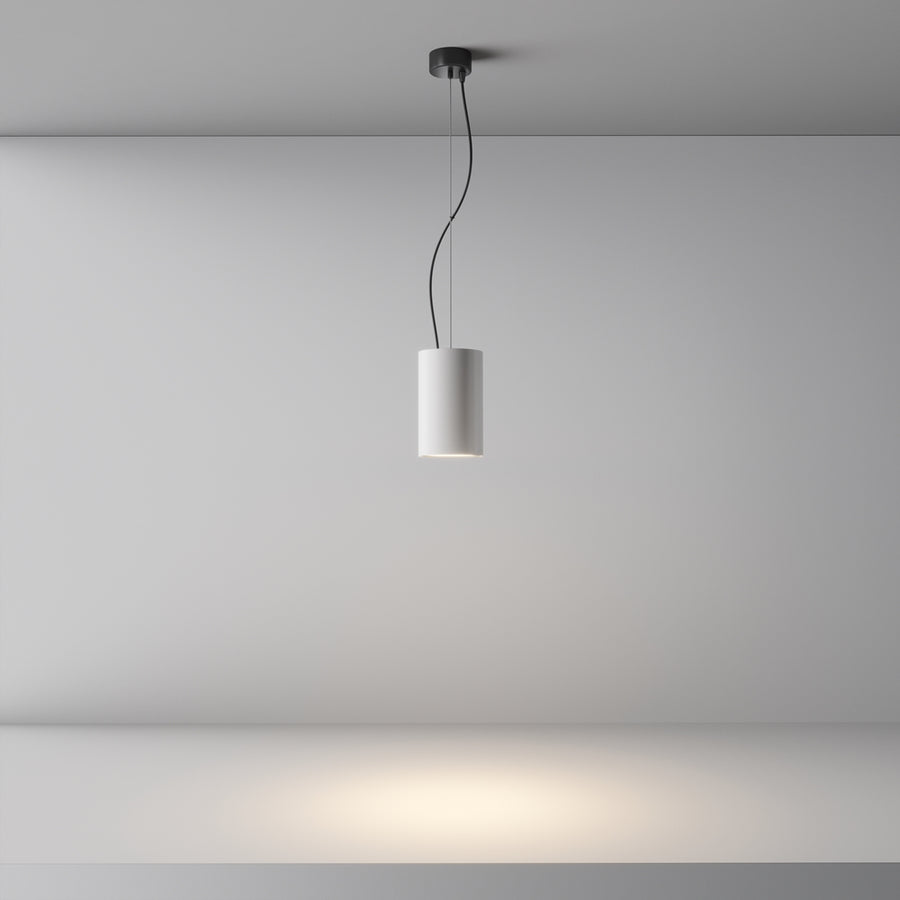 Vue d'ensemble de la suspension allumée projetant un halo lumineux au mur.