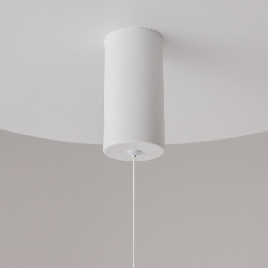 Gros plan de la rosace cylindrique blanche fixée au plafond, câble descendant