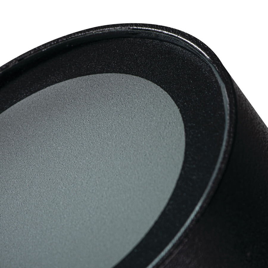 Gros plan sur le diffuseur gris clair et la bordure noire texturée du luminaire.