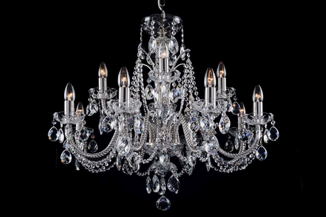 Même lustre en finition argentée, cristaux taillés et bras recourbés sur fond noir