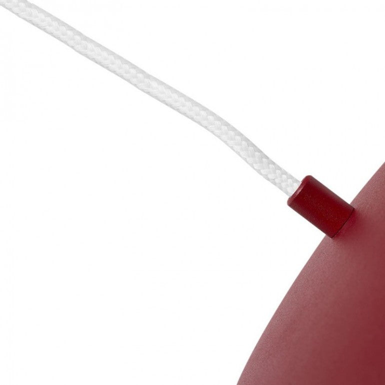 Détail du câble tressé blanc entrant dans le chapeau rouge laqué