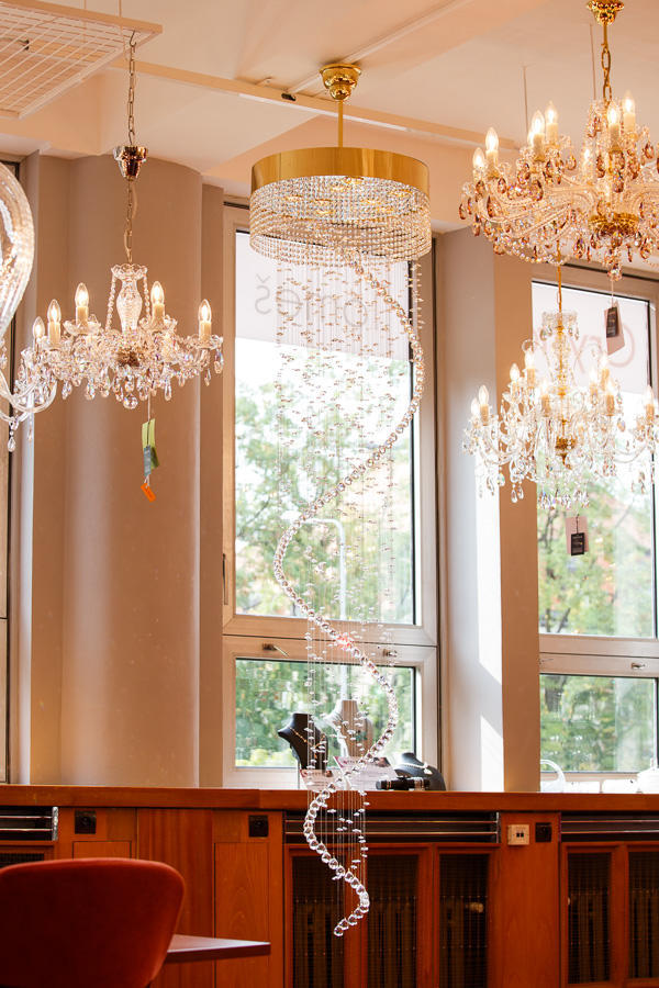 Vue en showroom, suspension dorée parmi d'autres lustres classiques suspendus