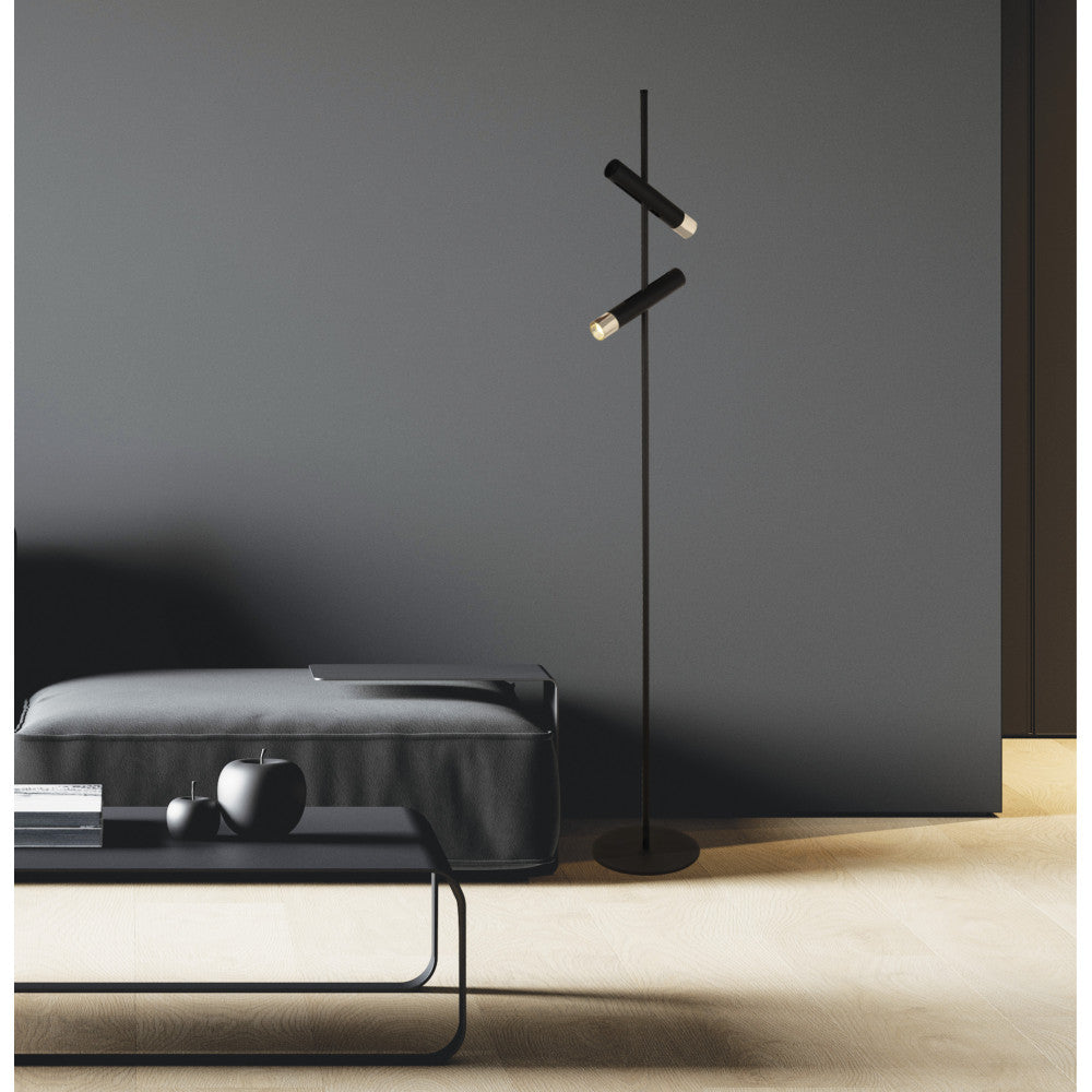 Ambiance sombre avec lampadaire allumé près d'un pouf et d'une table basse.