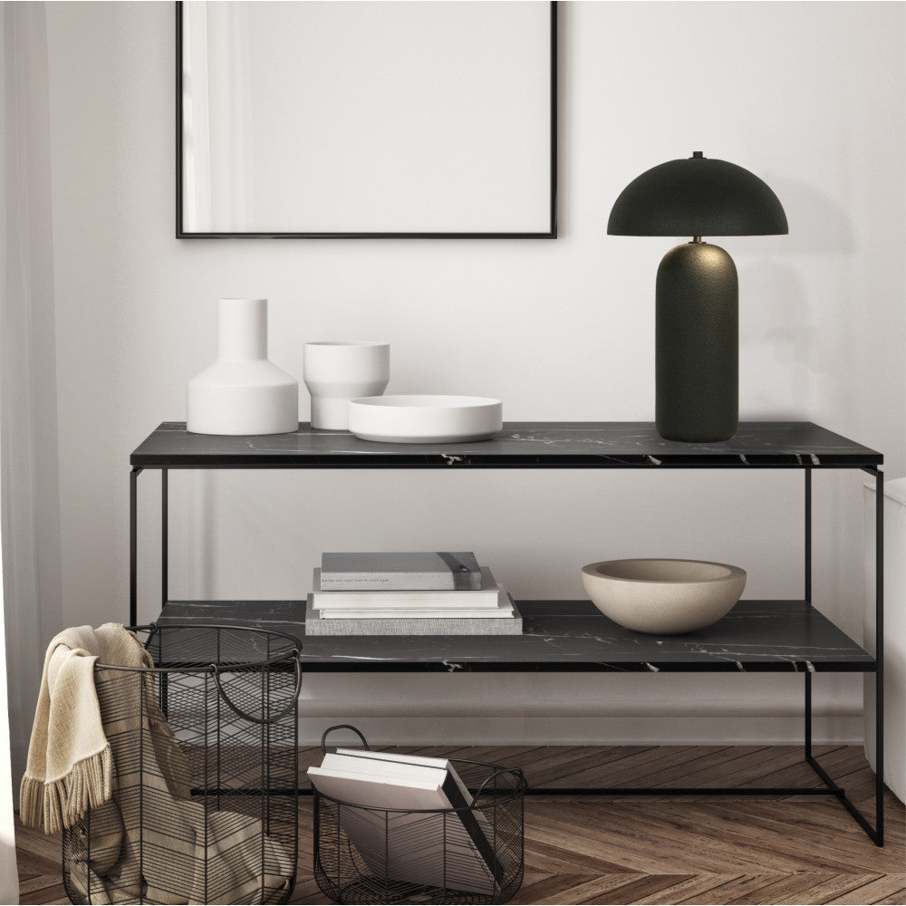 Lampe allumée posée sur une table console en marbre noir