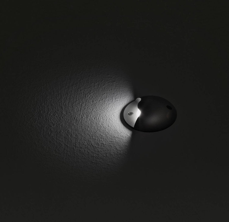 Mise en ambiance nocturne du luminaire encastré éclairant une surface texturée.