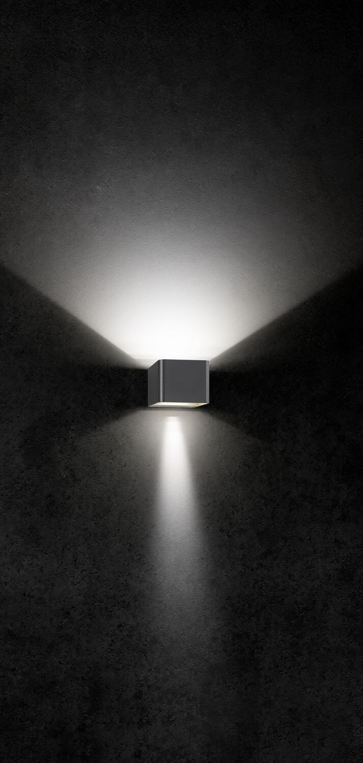 Mise en ambiance nocturne de l'applique murale anthracite diffusant un halo haut et bas