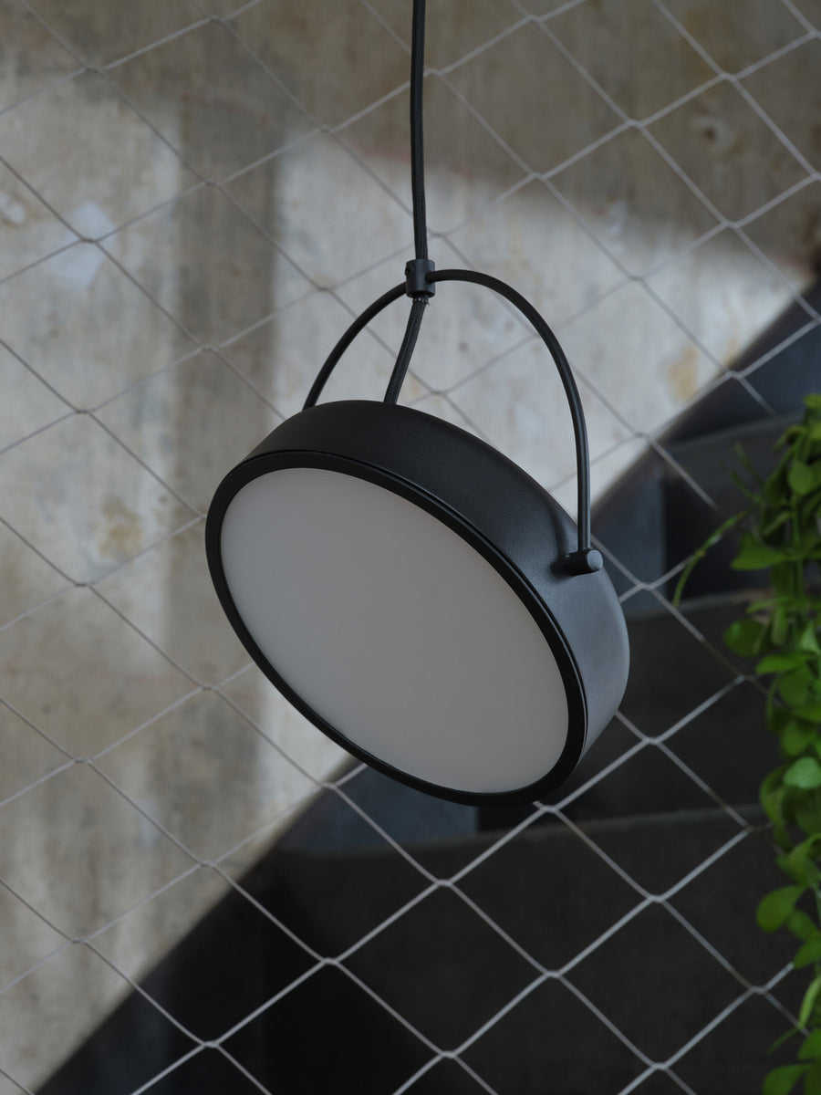 Gros plan sur le luminaire suspendu montrant la finition noire mate du bord.