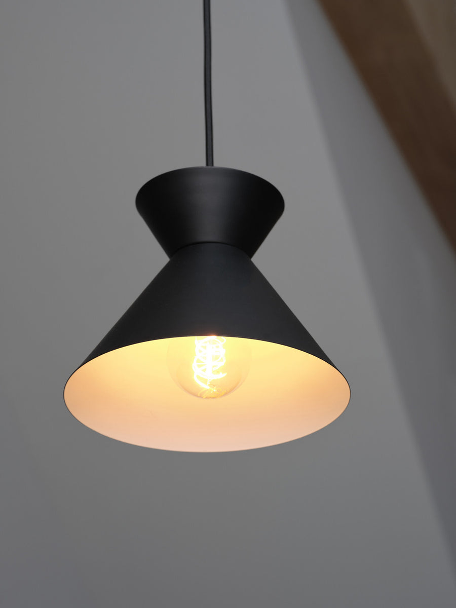 Détail rapproché de l’abat-jour conique noir avec ampoule LED allumée.