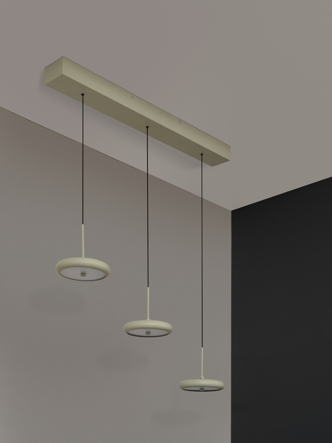 Vue en contre-plongée du rail de fixation et des trois câbles noirs suspendus.