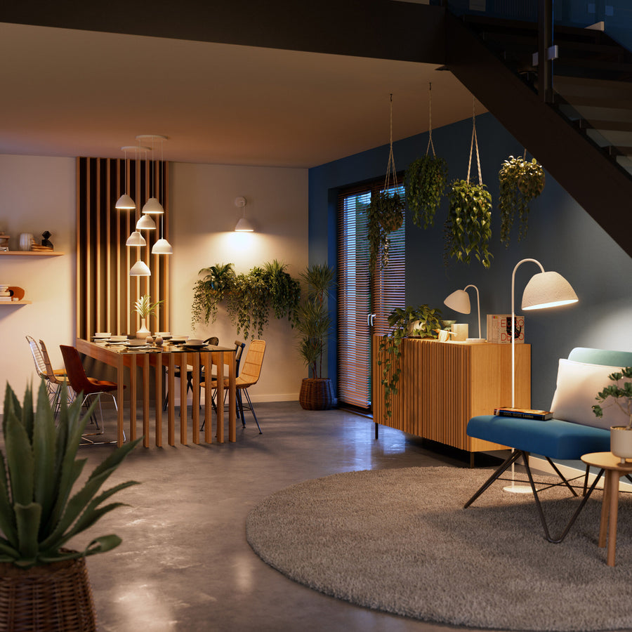 Salon chaleureux de nuit avec plusieurs suspensions et lampes allumées