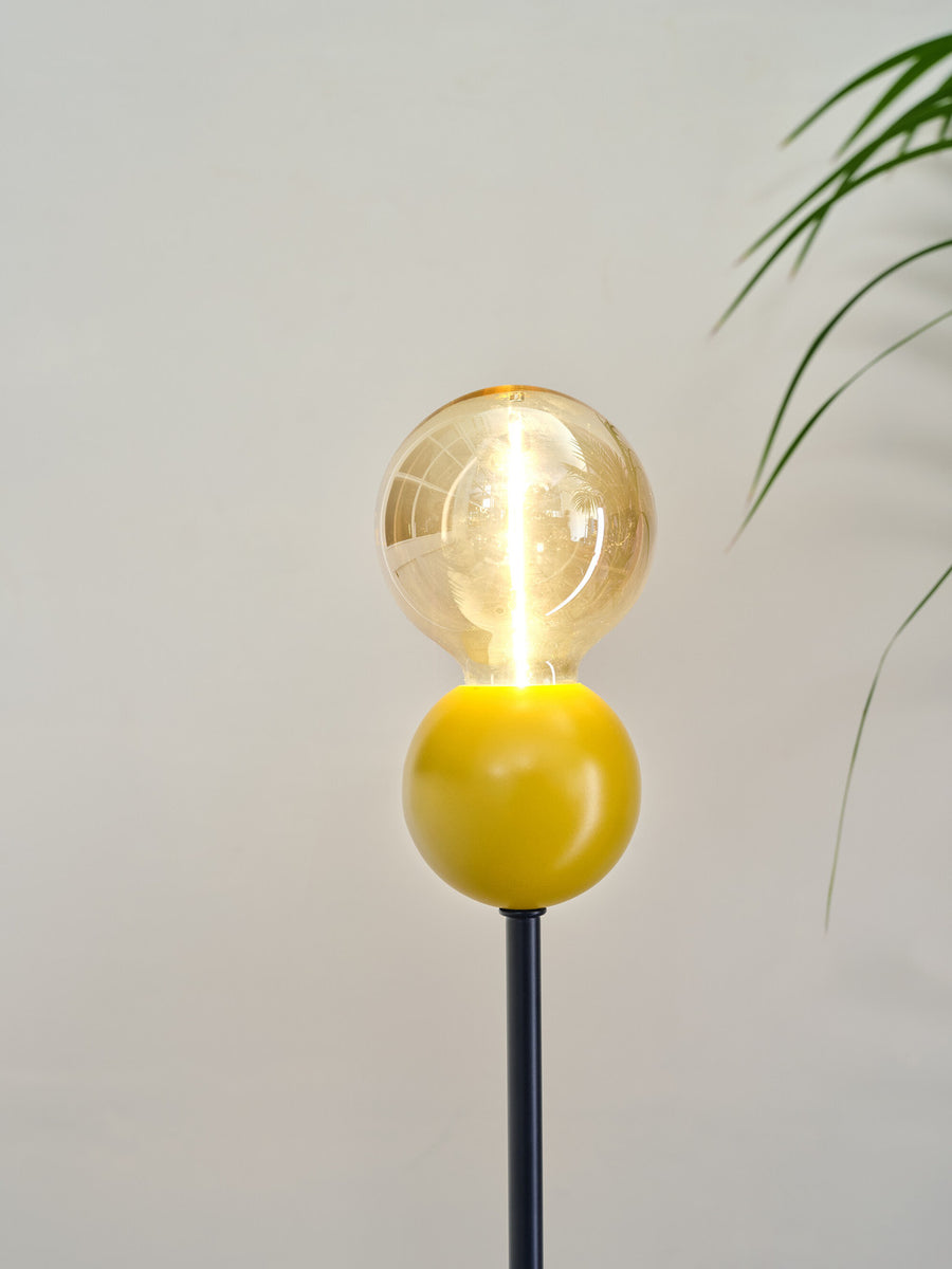 Détail rapproché de la sphère jaune et de l'ampoule transparente allumée