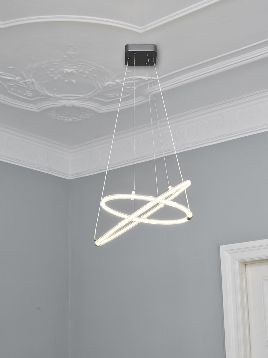 Vue en contre-plongée de la suspension sous un plafond mouluré dans une pièce grise.
