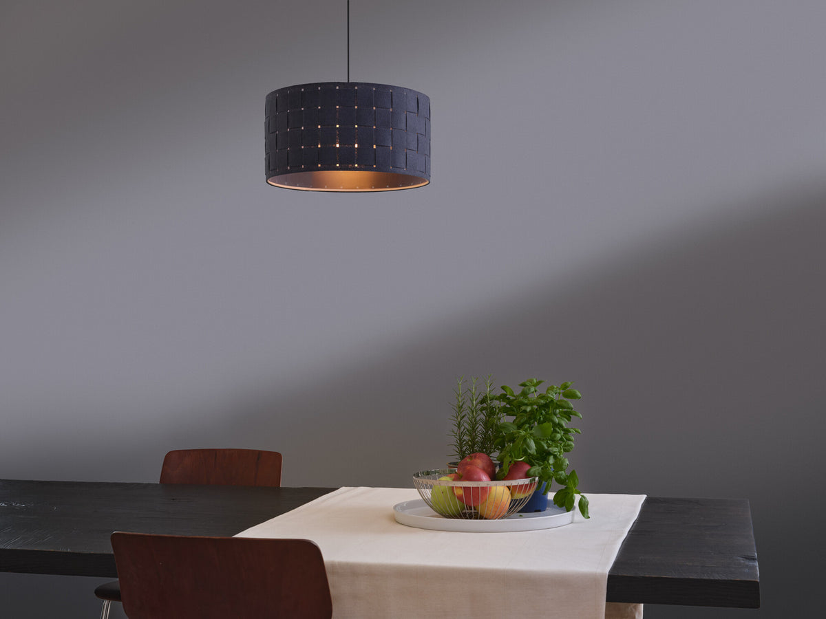 Mise en ambiance au-dessus d'une table noire dressée avec fruits et plantes.
