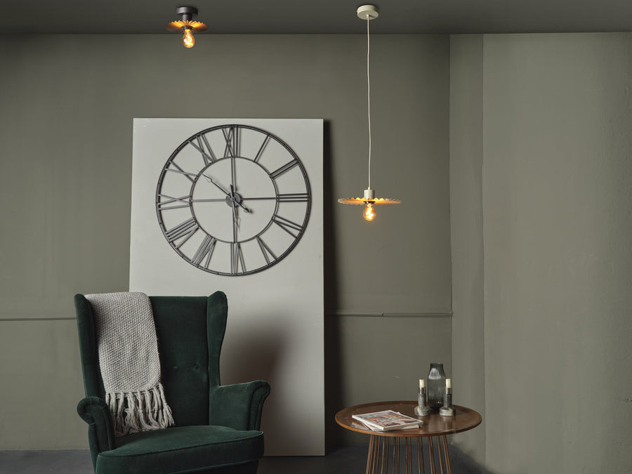 Suspension plissée et plafonnier identique dans un salon avec horloge et fauteuil.