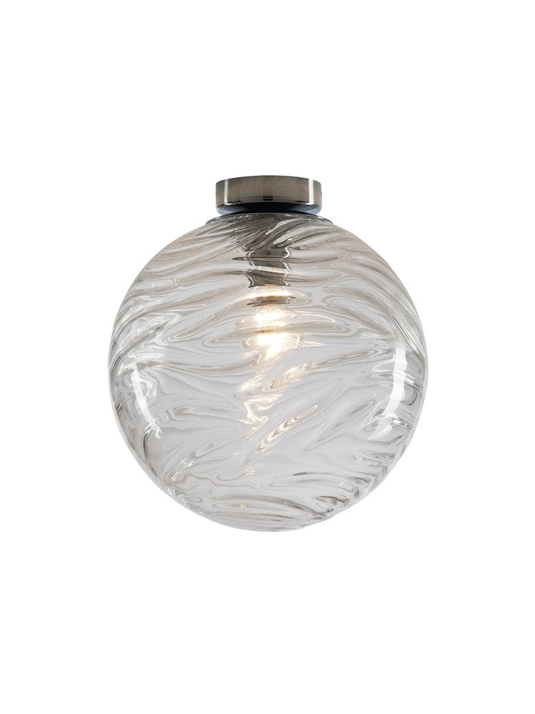 Vue rapprochée du globe en verre aux reflets marbrés, douille métallique chromée visible au sommet