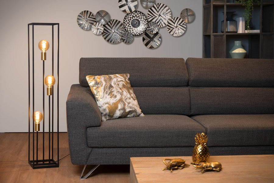 Vue d'ensemble du lampadaire noir dans un salon avec canapé et coussin doré
