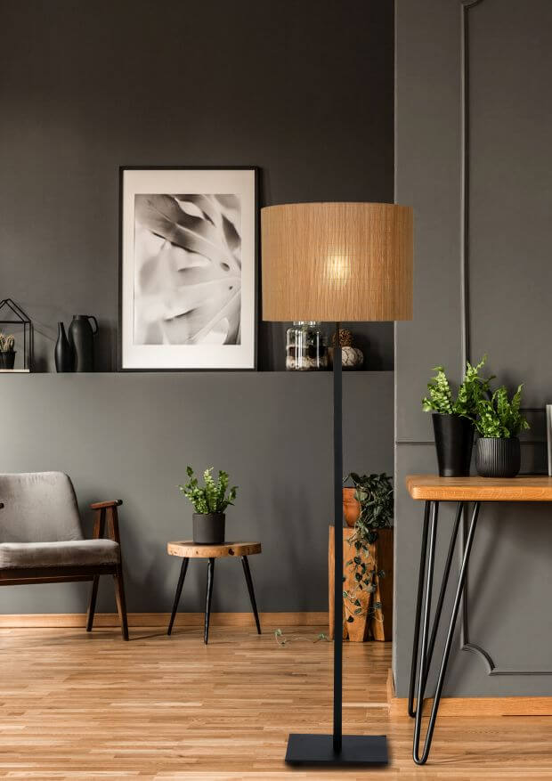 Vue en intérieur du lampadaire sur parquet clair, près d'un bureau et de plantes vertes.