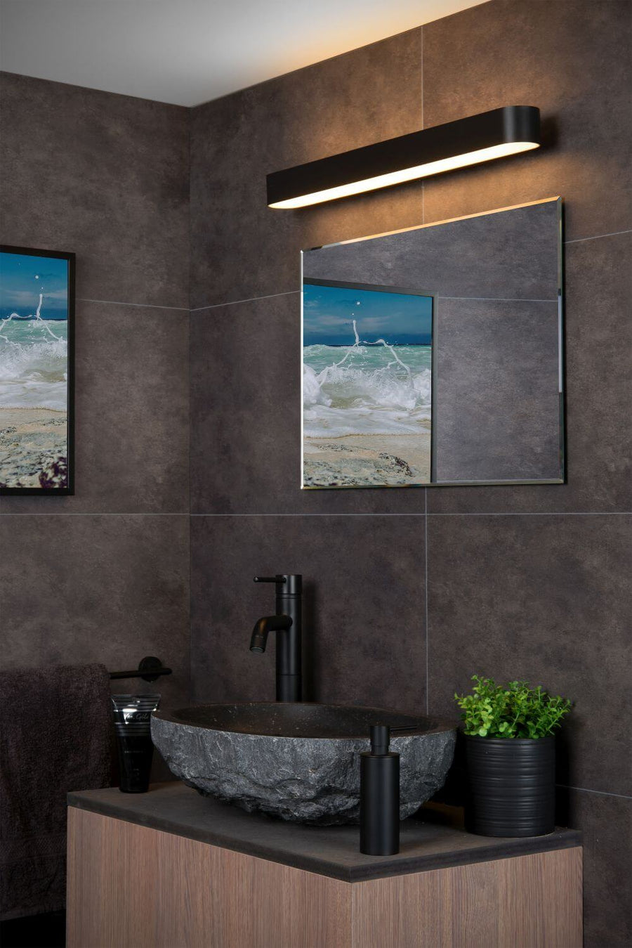 Vue rapprochée de l'applique murale noire et opale fixée au-dessus du miroir.