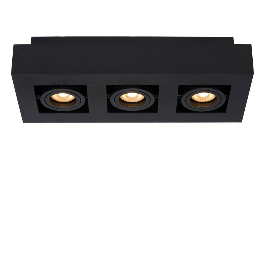 Vue frontale du plafonnier aux trois spots orientables diffusant une lumière ambrée