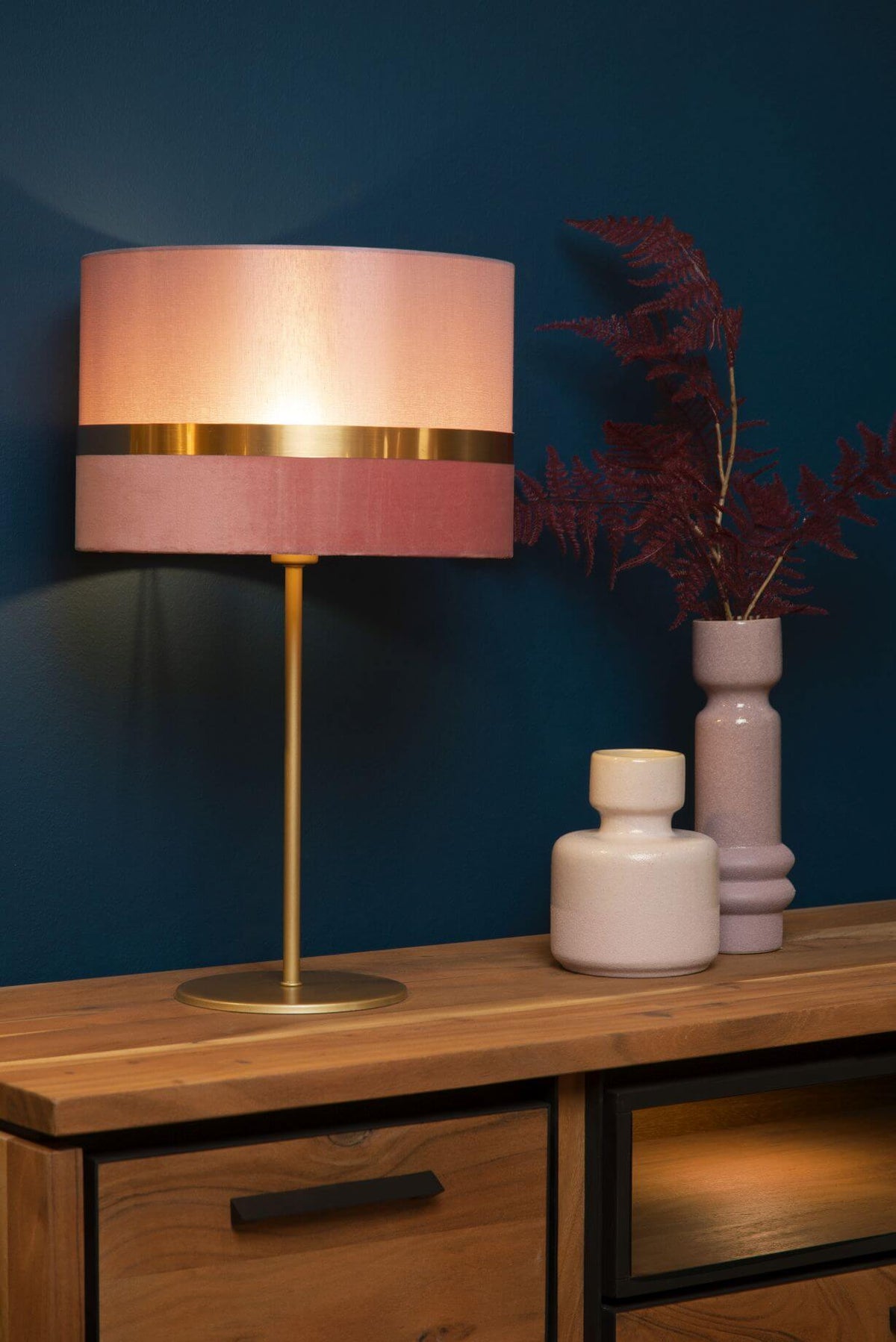 Mise en ambiance sur console en bois, lampe allumée près de deux vases