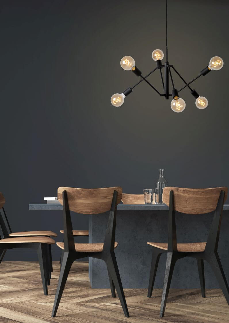 Mise en ambiance au-dessus d'une table de salle à manger sombre avec chaises en bois.