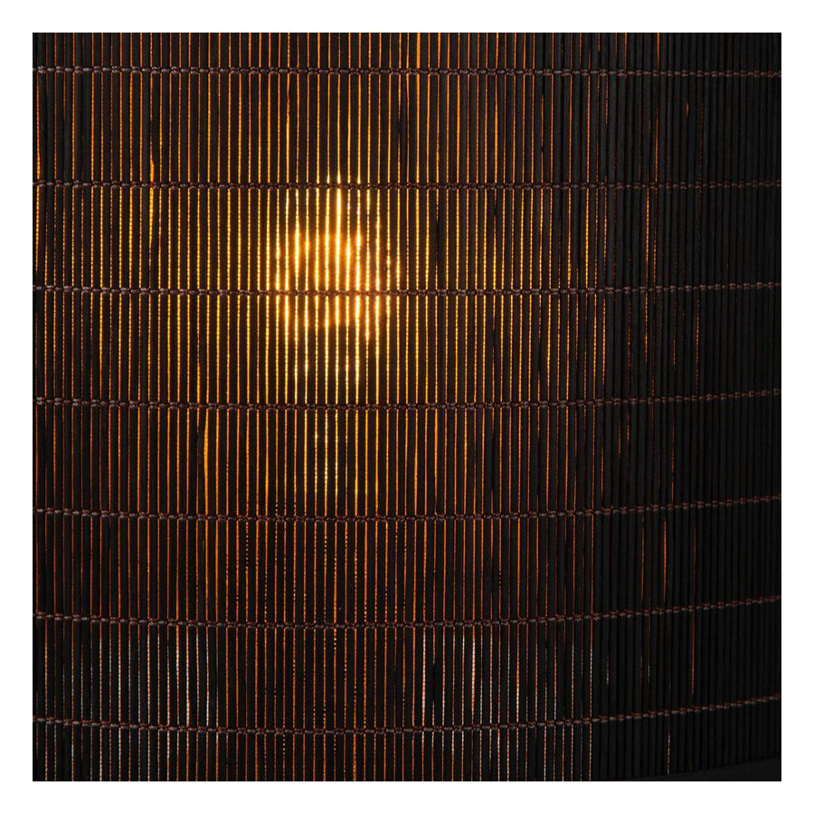 Détail de la finition tressée de l’abat-jour, avec lumière chaude filtrant entre les lamelles verticales.