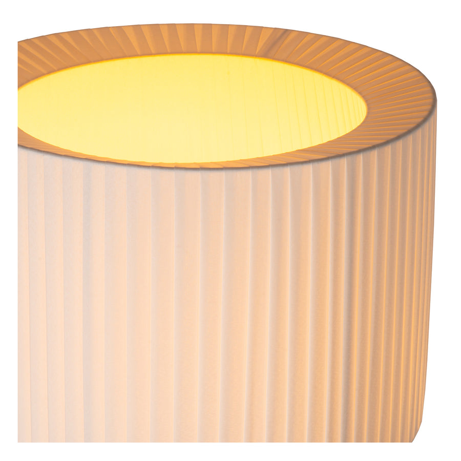 Détail du haut de l'abat-jour plissé, intérieur éclairé jaune et monture centrale.