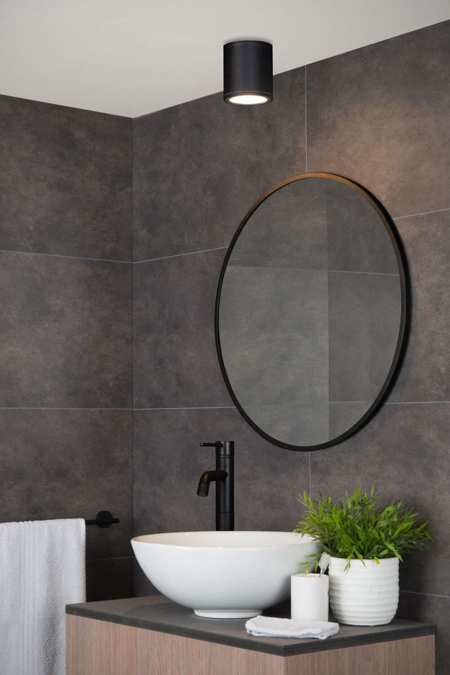 Vue rapprochée du luminaire noir fixé au-dessus du lavabo et du miroir