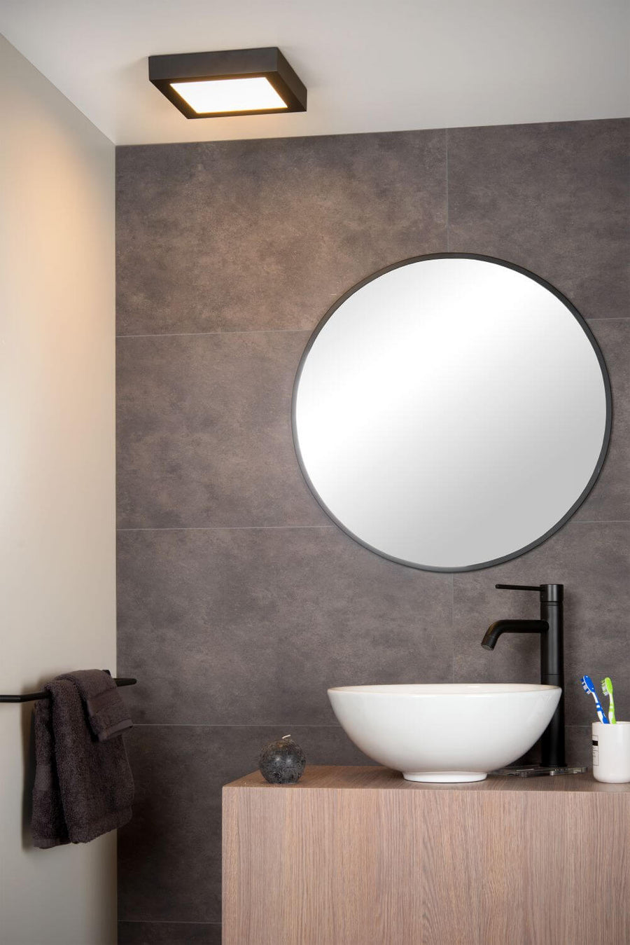 Vue en situation du luminaire noir carré fixé au plafond au-dessus du miroir