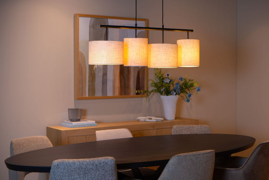 Suspension beige suspendue devant un tableau encadré dans une salle à manger.