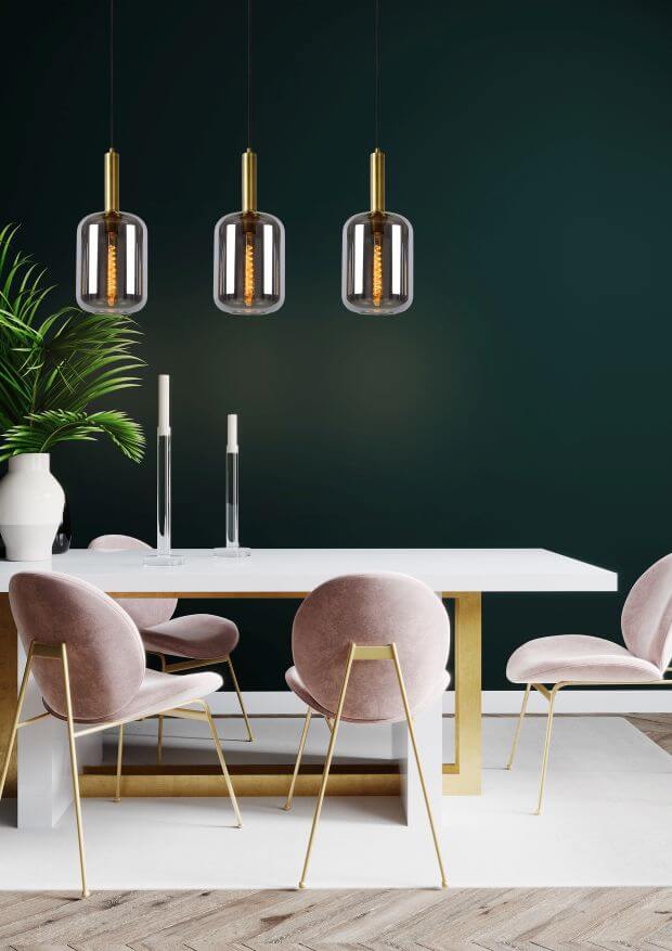 Mise en ambiance sur mur vert foncé avec chaises roses et table blanche