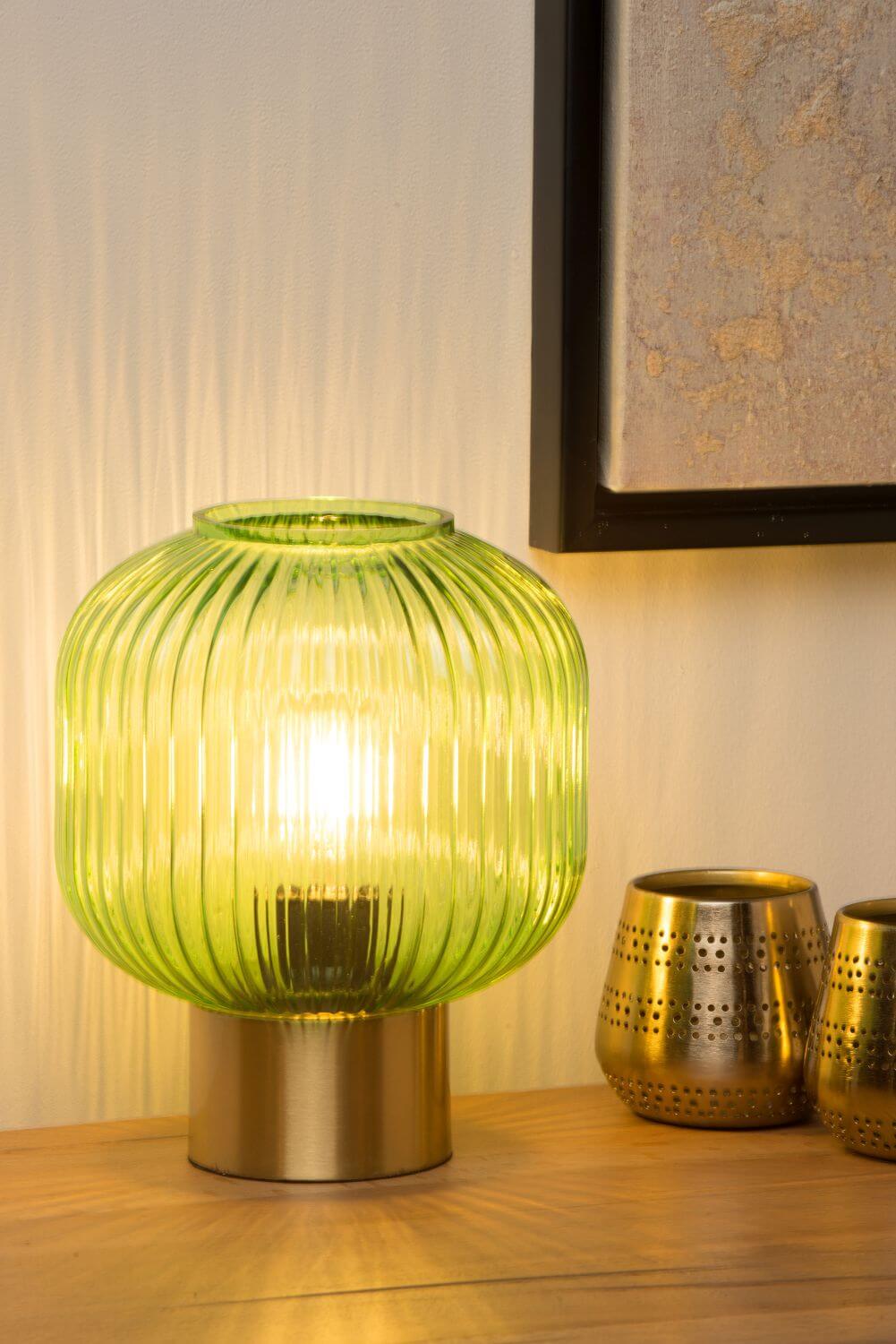 Mise en ambiance chaleureuse, lampe allumée sur un buffet devant un mur beige