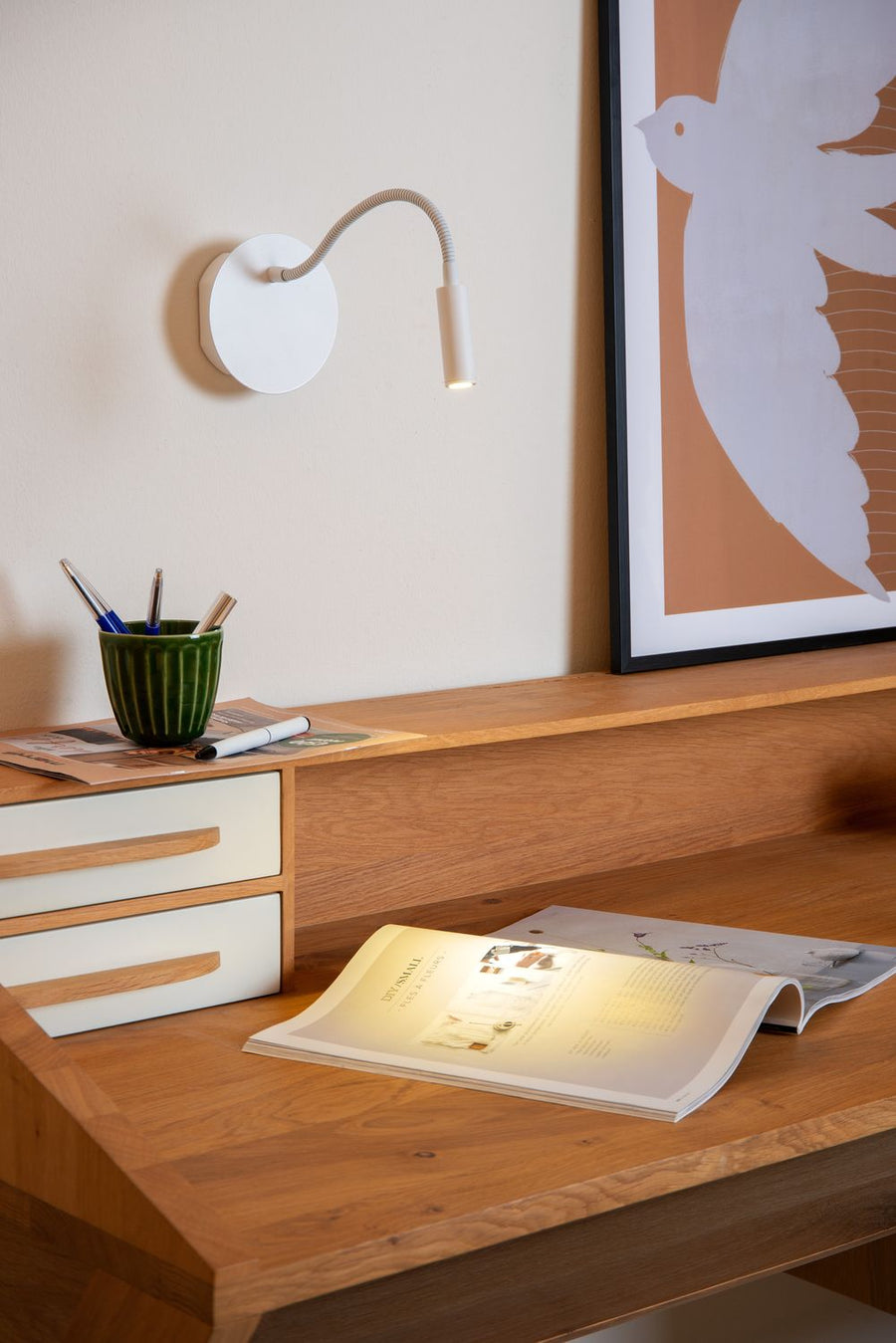 Vue rapprochée du luminaire allumé éclairant un magazine posé sur le plan de travail