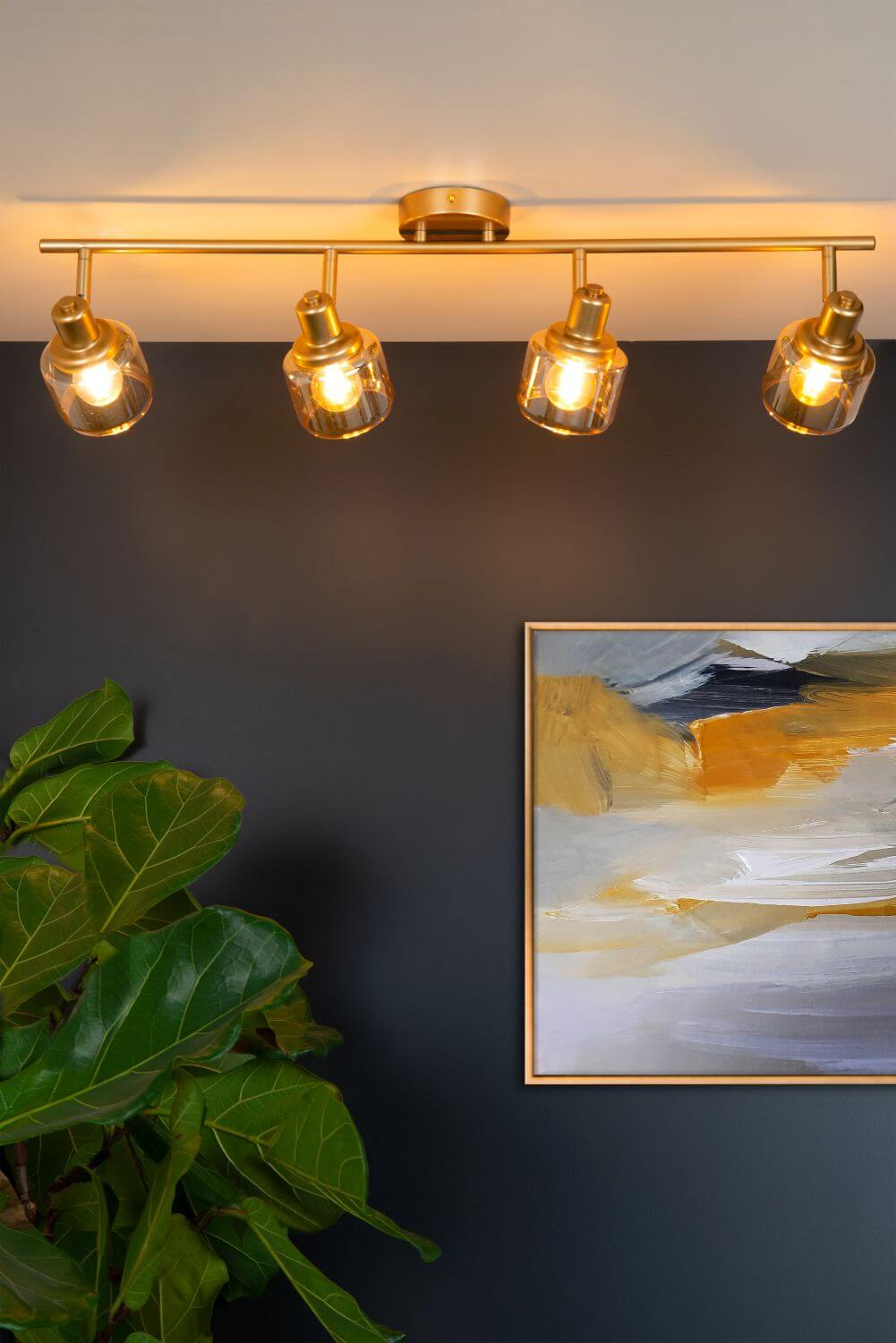 Mise en ambiance avec plante verte et tableau abstrait sous le plafonnier