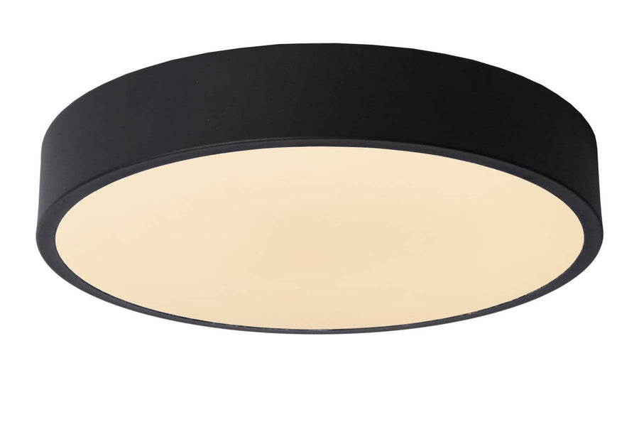 Vue rapprochée du luminaire noir et de sa coupole opaline blanche, éclairage chaud.