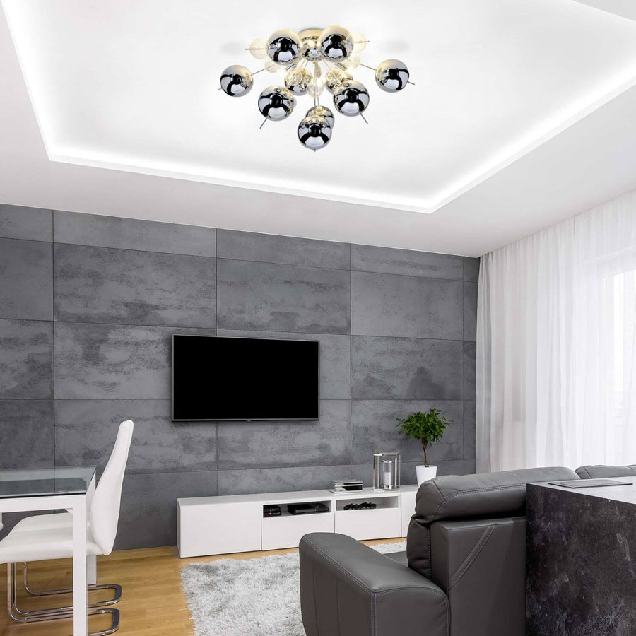 Plafonnier chromé vu de dessous dans un salon gris avec mur effet béton