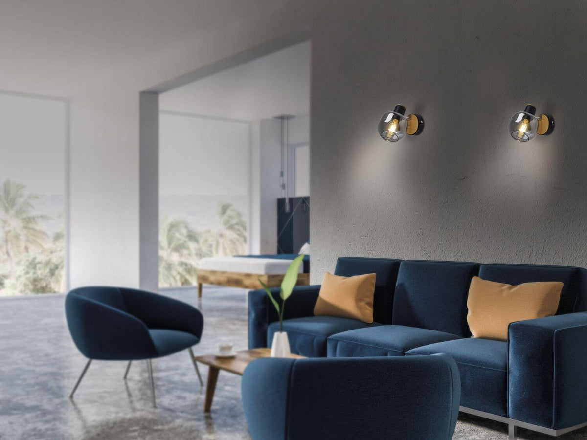 Mise en ambiance d'un salon moderne avec deux appliques murales allumées sur un mur gris.