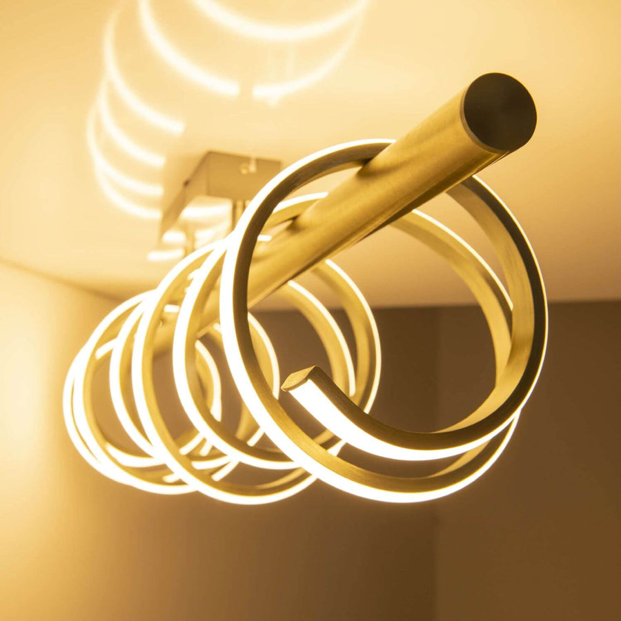 Détail rapproché des spirales dorées éclairées diffusant une lumière chaude