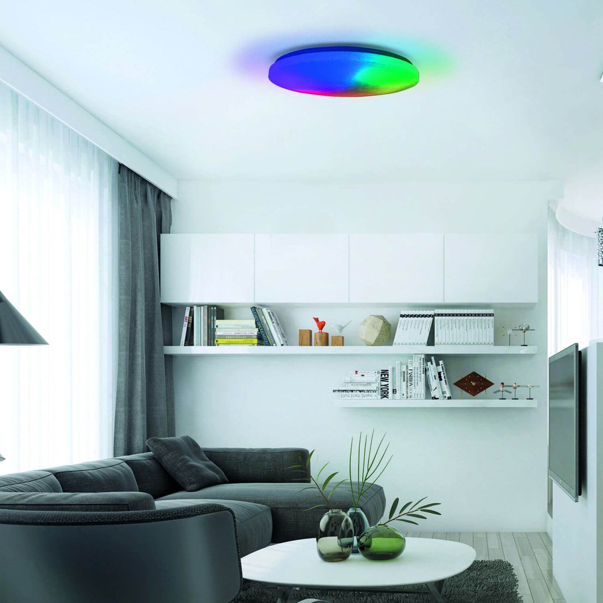 Mise en ambiance dans un salon avec le plafonnier diffusant un dégradé multicolore.