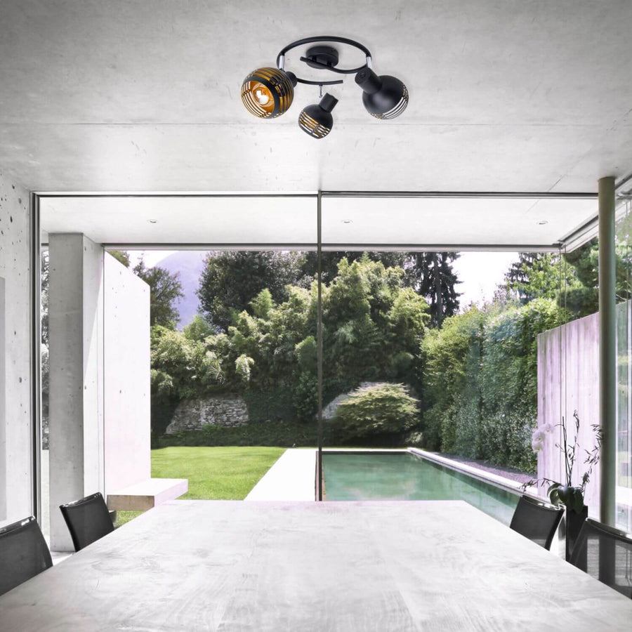 Plafonnier installé au plafond dans une salle à manger ouverte sur une piscine et un jardin.