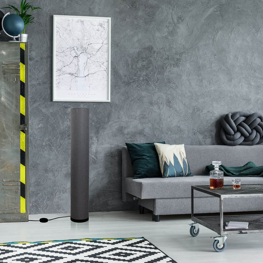 Lampadaire installé dans un salon gris, près d'un canapé et d'une table basse.