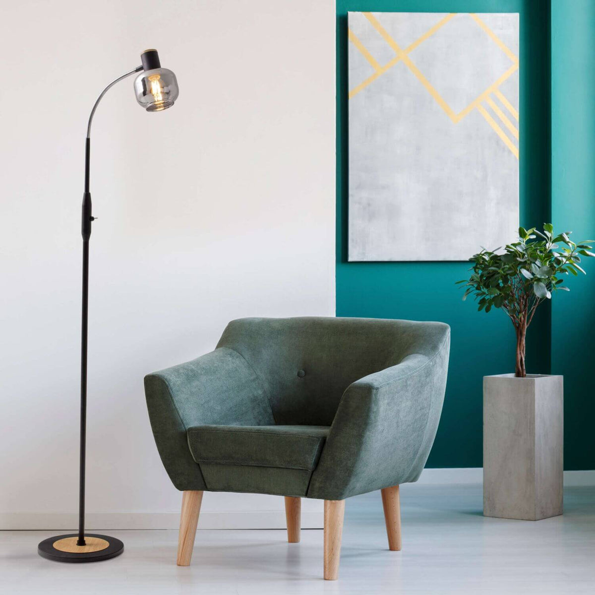 Mise en ambiance dans un salon avec fauteuil vert, tableau jaune et plante.