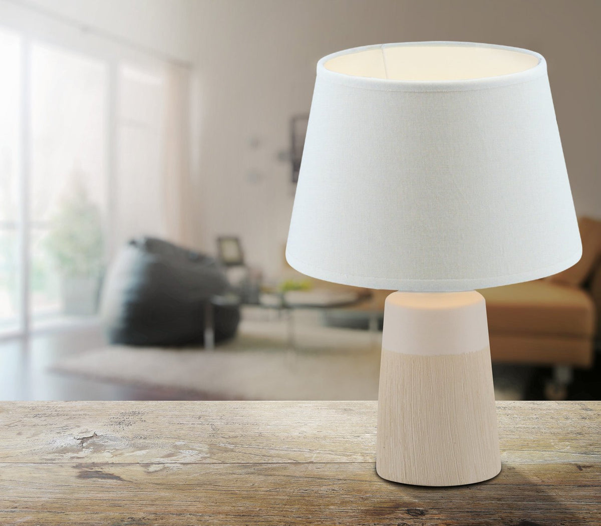 Mise en ambiance : lampe allumée posée sur une table en bois dans un salon.