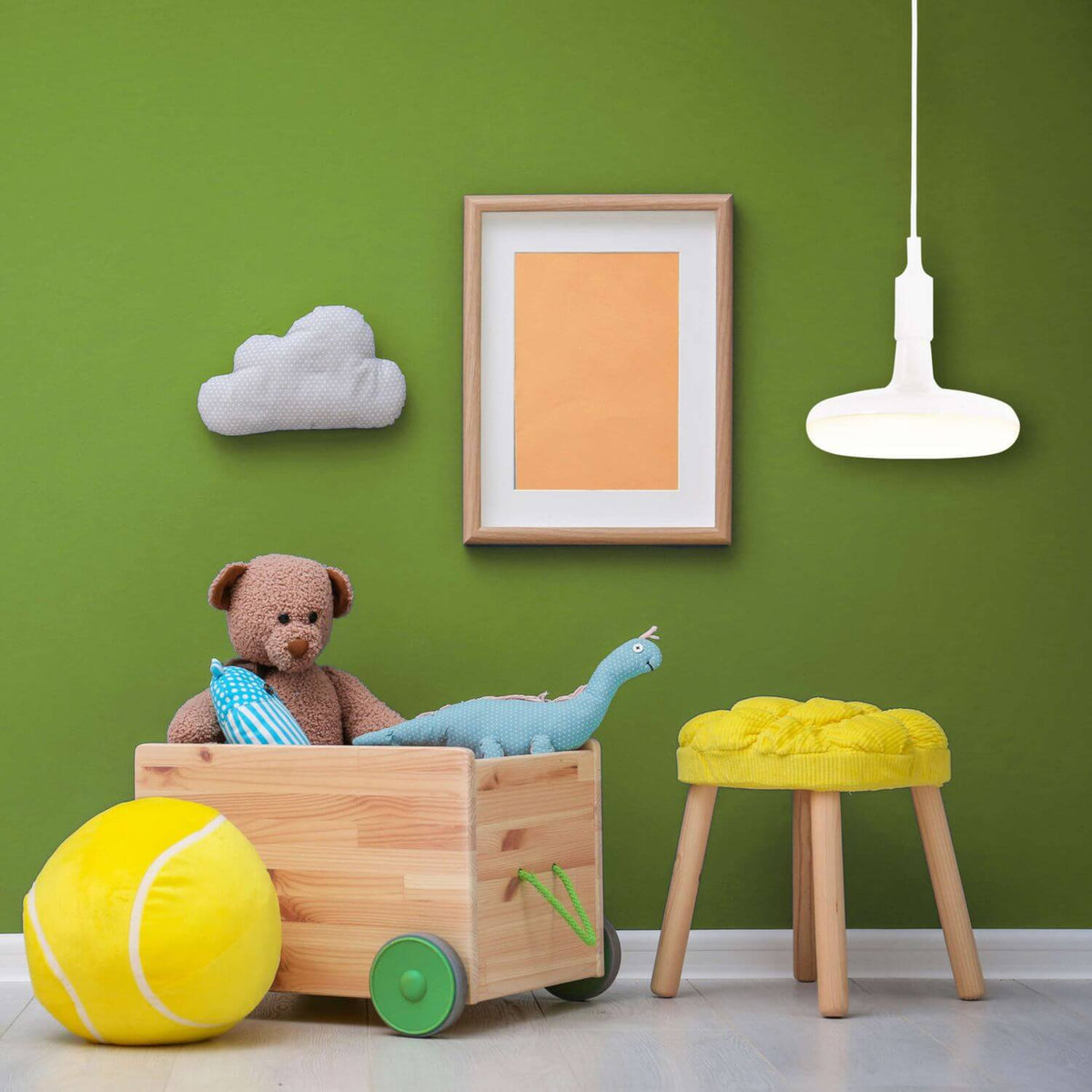 Lampe suspendue blanche dans une chambre d'enfant verte, jouets en bois et pouf jaune