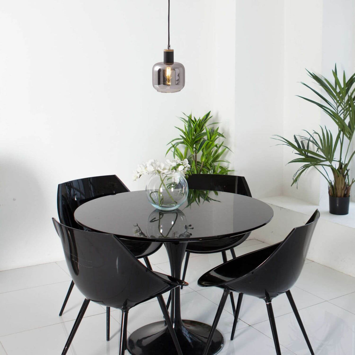 Suspension allumée au-dessus d'une table ronde noire dans un intérieur