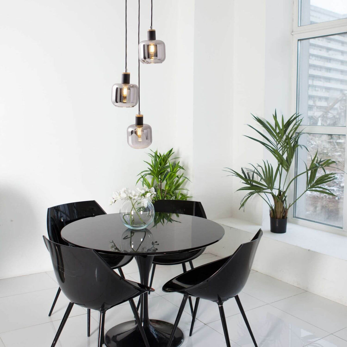 Mise en ambiance au-dessus d'une table à manger noire entourée de chaises design
